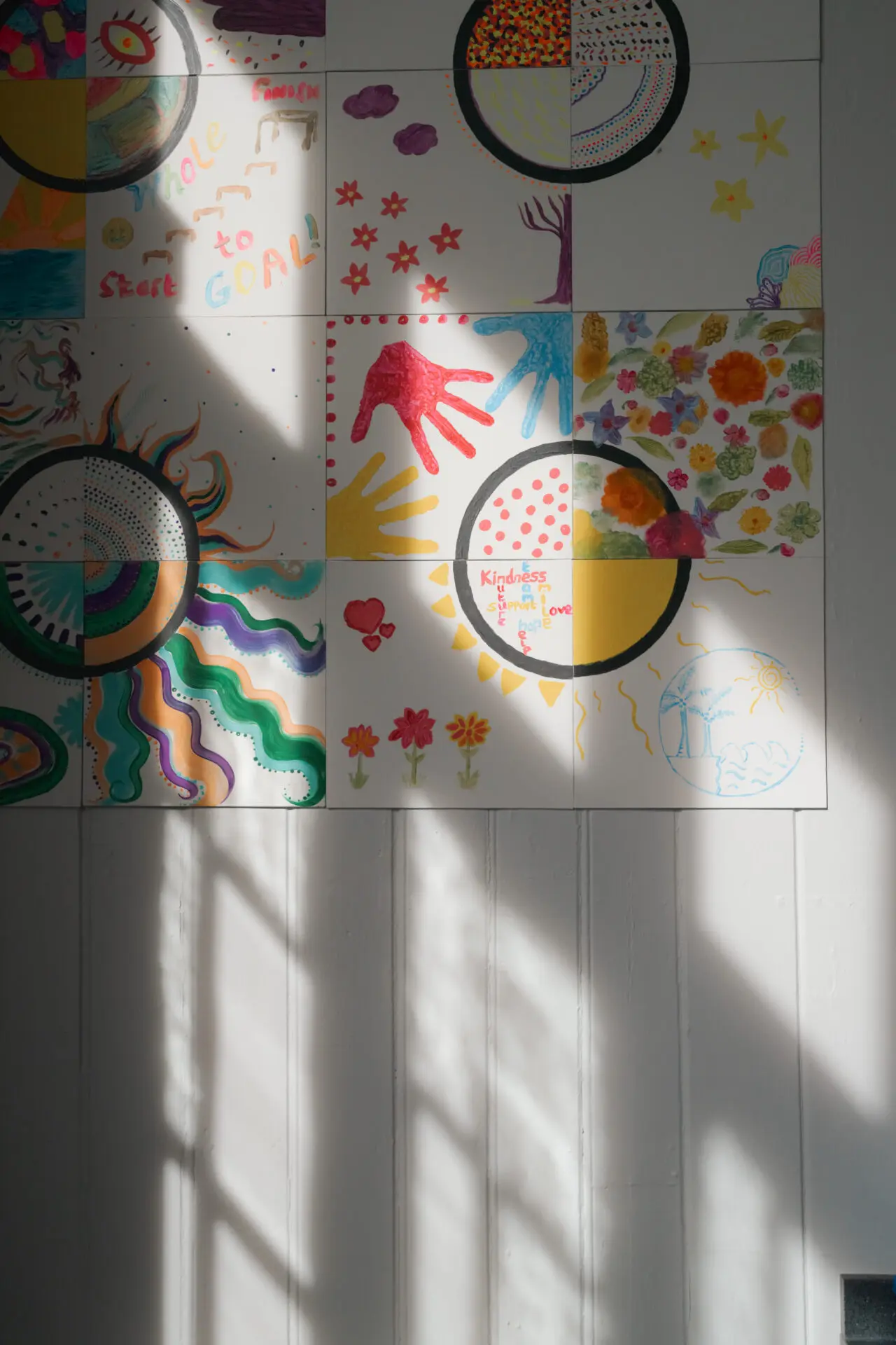 Image of colourful tiles on a wall that pupils have painted