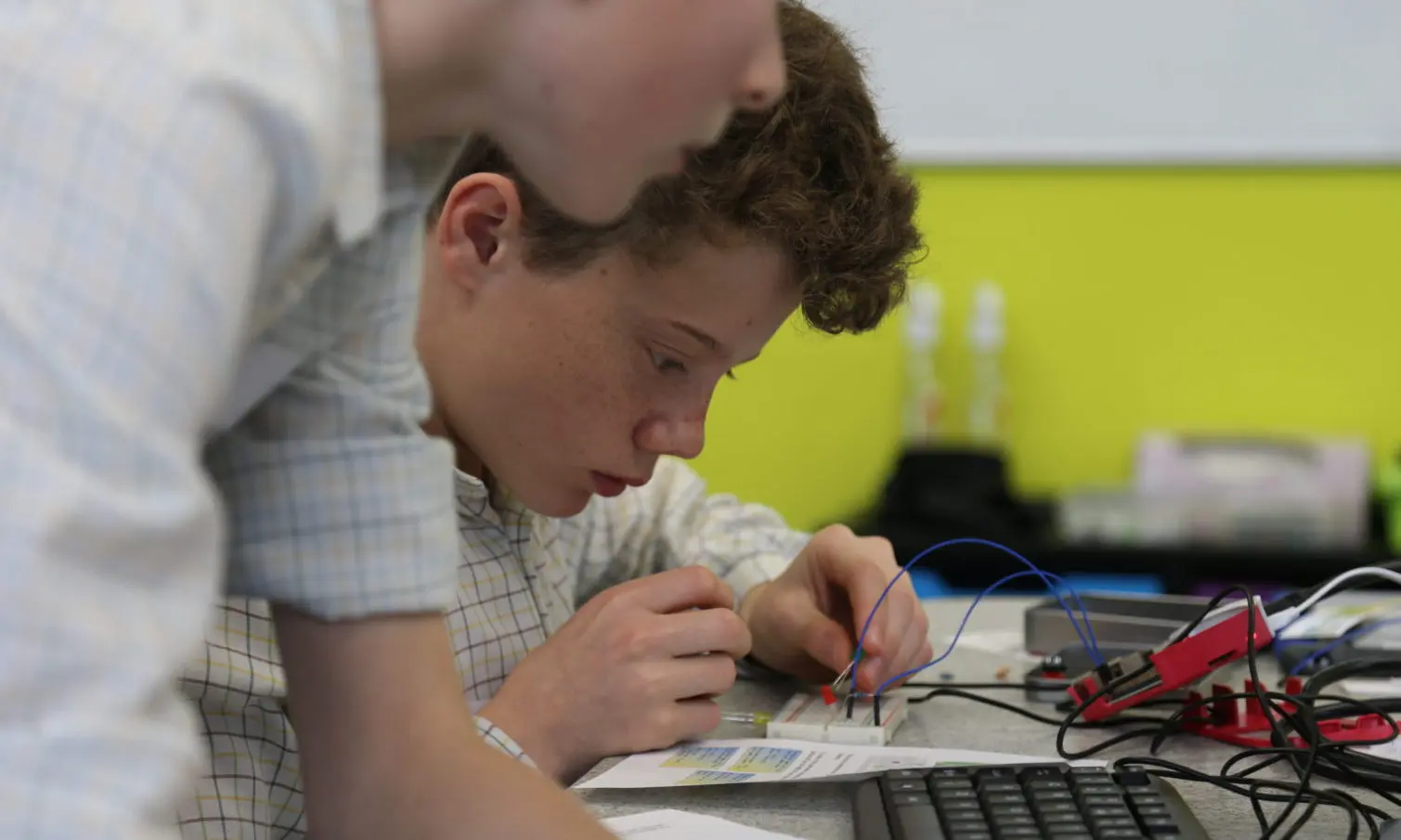 Image of a student soldering a computer chip board