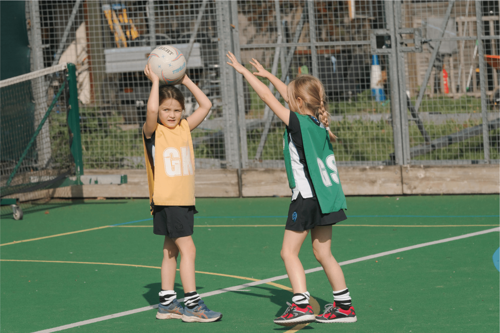 Photo of two school girls playing Netball