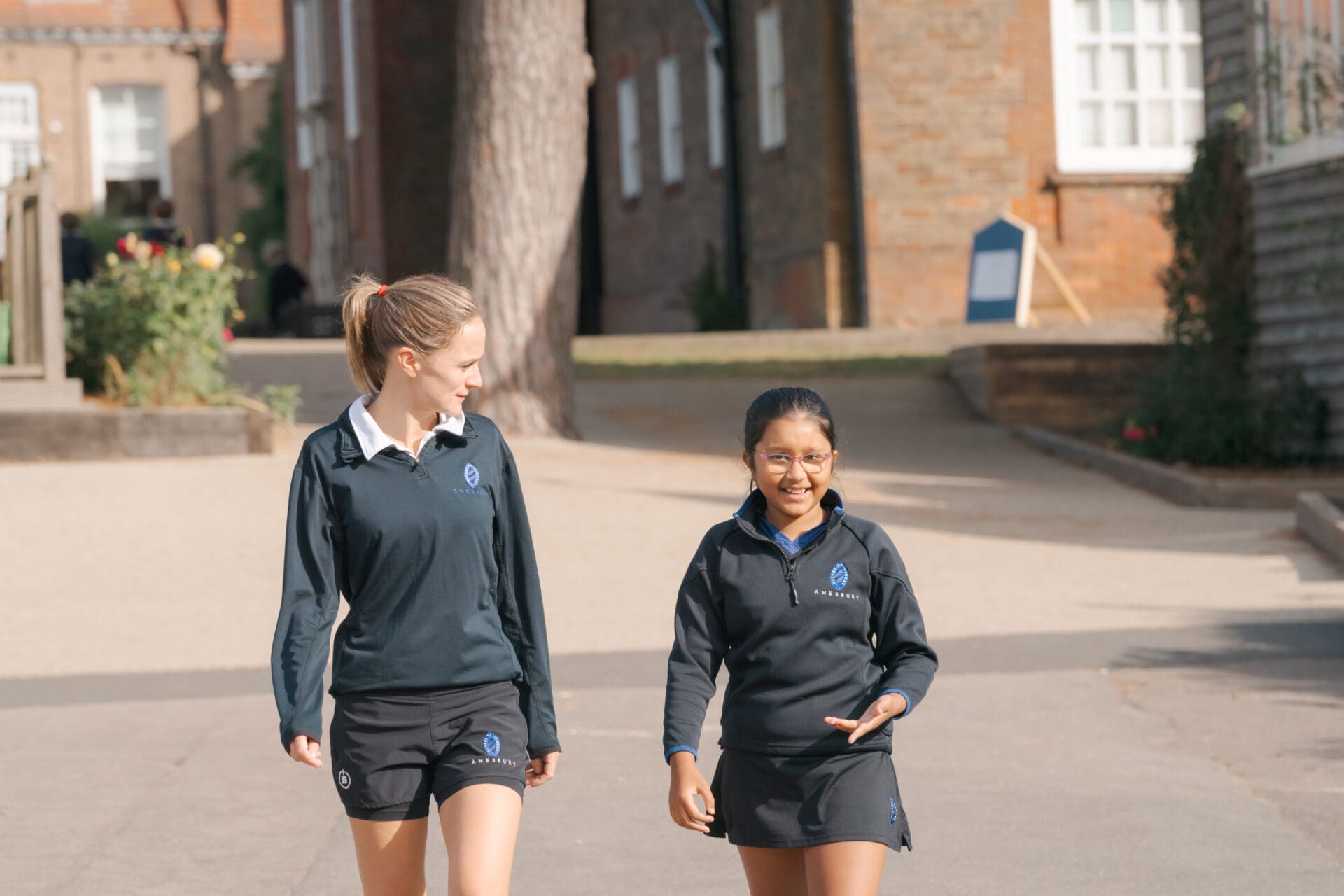 Image of a teacher and student walking through the grounds