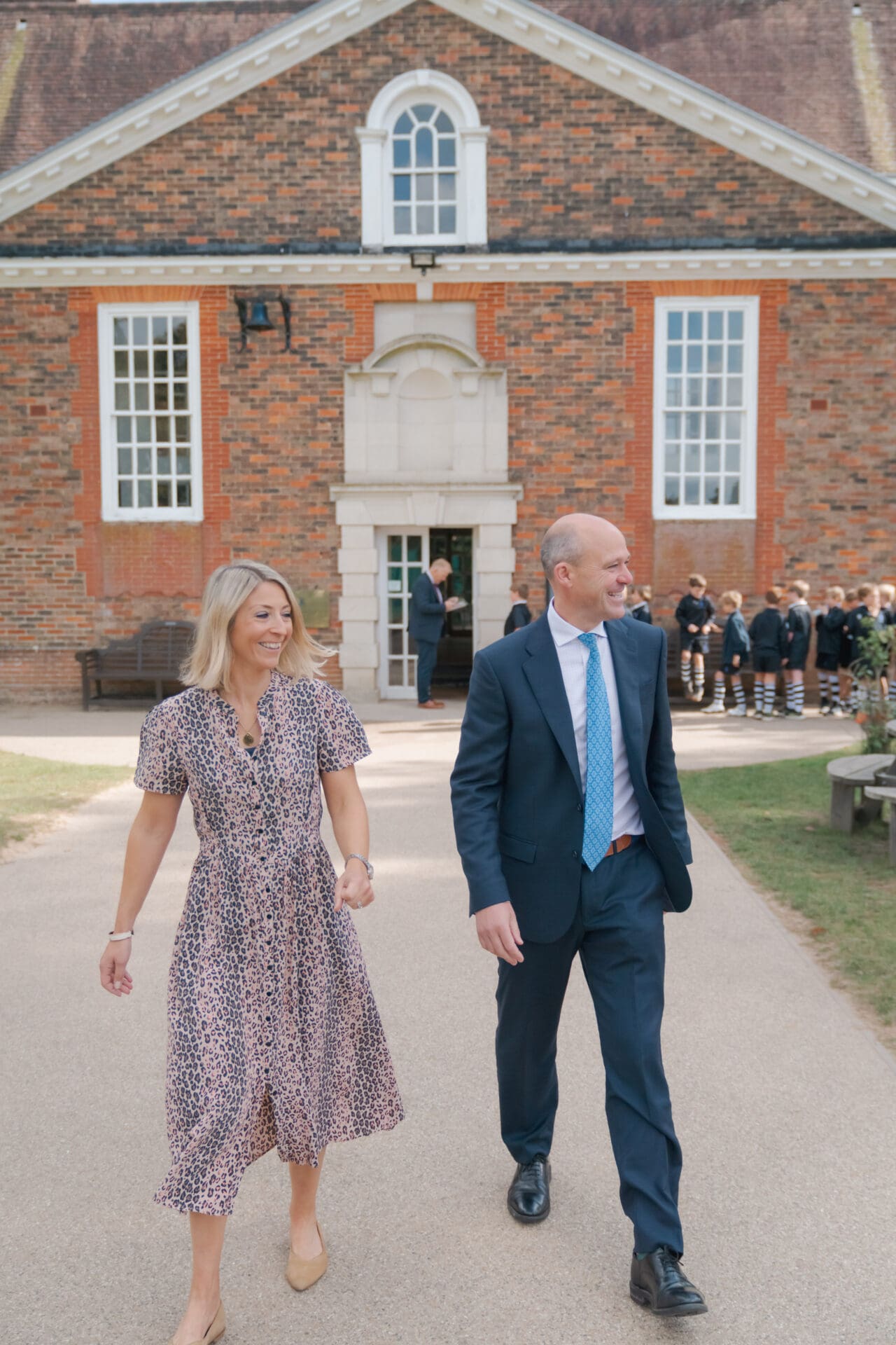 Image of the head and his wife walking around the school grounds