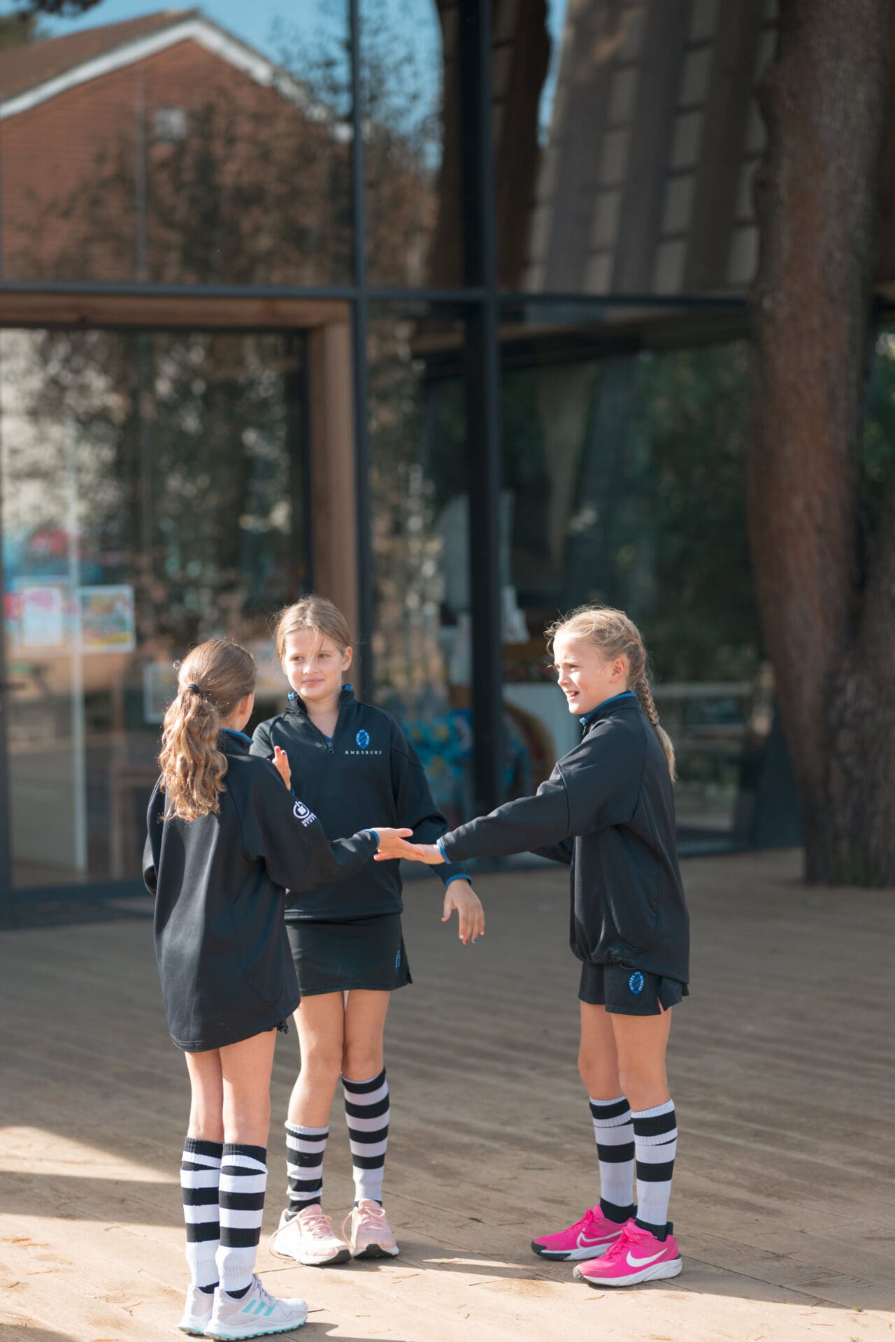 Image of 3 girls stood in a circle talking